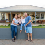 Newcastle family standing in front of their home